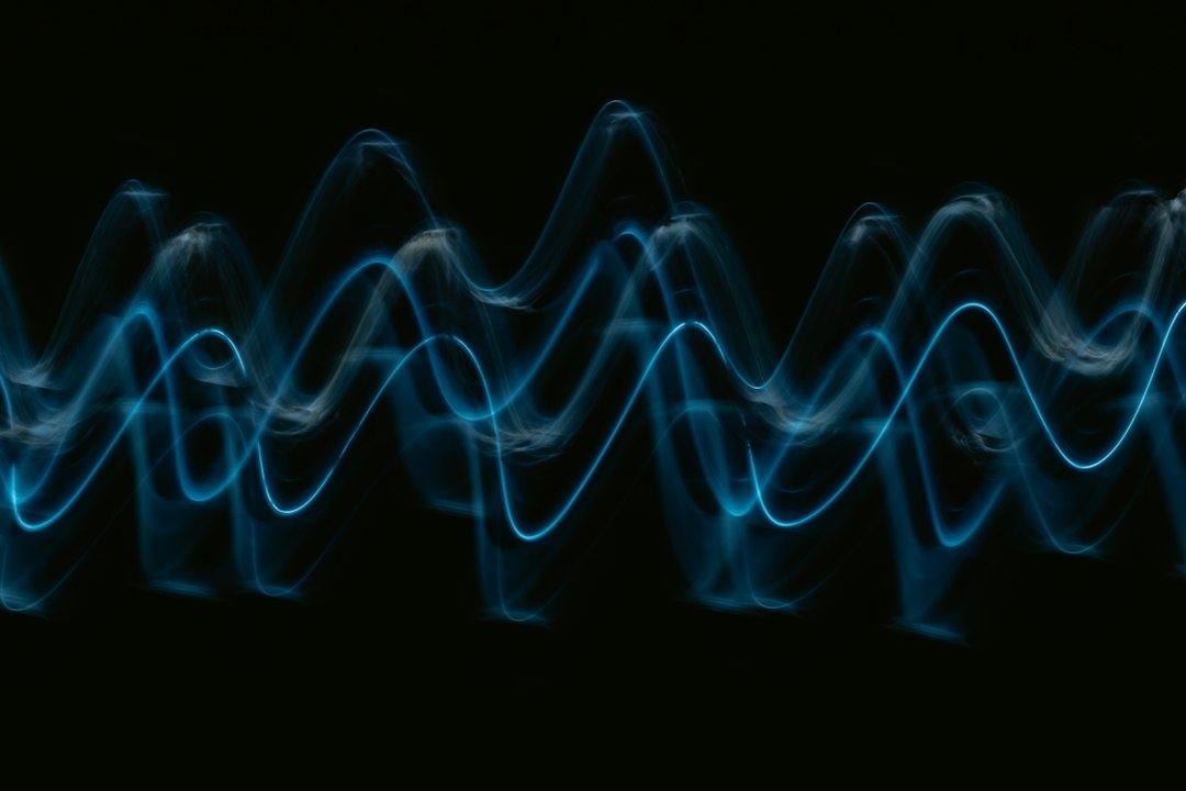 Leuchtend blaue, wellenförmige Linien vor schwarzem Hintergrund